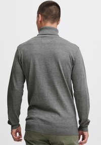 Gray turtleneck sweater with long sleeves, ribbed fabric at the collar and cuffs, featuring a smooth texture and fitted design.