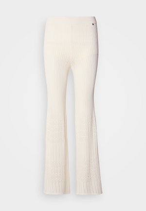 Rippstrick, cremefarbene Strickhosen mit ausgestellten Beinen und einem strukturierten Spitzenmuster am unteren Saum. Weiches Material mit einem enganliegenden Bund.