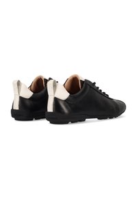 Schwarze Ledersneaker mit glatter Oberfläche, die eine kontrastierende weiße Ferse und subtile Perforationen aufweisen. Minimalistisches Schnürdesign.