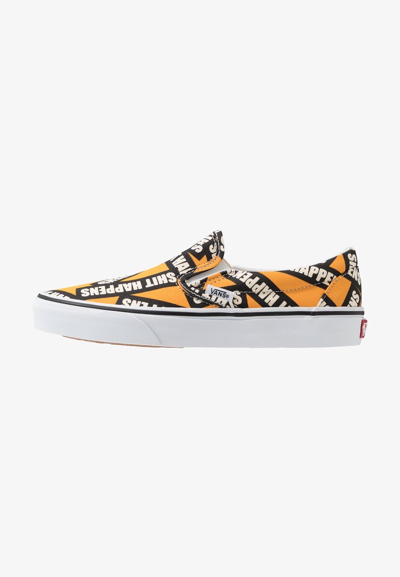 Chaussure Vans slip-on avec motif géométrique orange, noir et blanc, arborant la phrase « Shit Happens » répétée sur toute la tige en tissu.