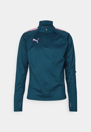 Teal lange mouwen sport pullover met een halve rits, roze schouderaccenten en een roze logo op de borst. Lichtgewicht, gladde textuur.