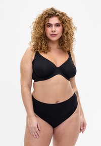 Black bra and high-waisted panties. Bra features molded cups, wide straps, and a smooth texture. Underwear has a seamless design.
