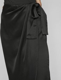 Gonna in satin nera con legatura laterale e design drappeggiato, con una texture liscia e una silhouette fluida.