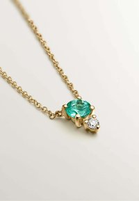Collar de cadena de oro que presenta una gran gema de turquesa y un pequeño diamante claro, ambos montados en engastes de oro pulido.