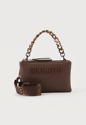 Sac à main marron Steve Madden avec poignée chaîne dorée et bandoulière large en tissu amovible sur fond blanc.