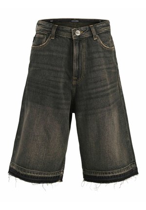 Junge steht, trägt ein kurzärmeliges Hemd mit Muster über einem weißen T-Shirt, dunkle Jeansshorts, hohe weiße Socken und braune Schnürschuhe.