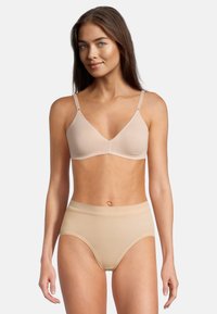 Reggiseno beige senza cuciture con spalline regolabili e superficie morbida e liscia, abbinato a una mutandina a vita alta, anch'essa beige.