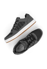 Grau-sportliche Schuhe aus einer Kombination aus glatten und strukturierten Materialien, mit einer weißen Sohle und Einsätzen aus Gummi. Enthält ein schwarzes Mesh-Element.