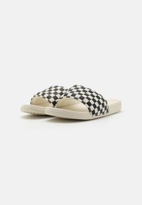 Black and white checkered slide sandals with a wide strap and a textured sole, featuring a cream-colored base and smooth finish.