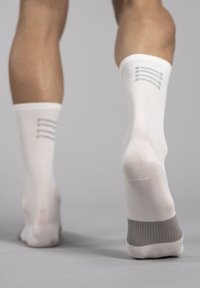 White compression socks with gray accent at the ankle, featuring horizontal gray stripes at the top, with a smooth, stretchy fabric.