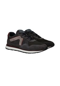 Grijze suède en mesh sneakers met zwarte veters, voorzien van rode en beige accenten, een witte middenzool en een gestructureerde rubberen buitenzool.