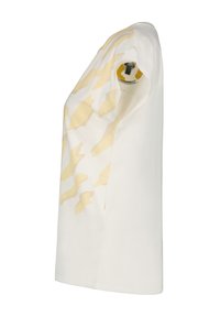 Camiseta blanca de manga corta con un patrón abstracto amarillo en la parte delantera, con un detalle redondo en la parte superior de la manga izquierda.