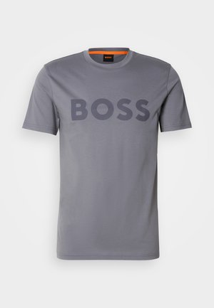 Camiseta de algodón gris con un gran logotipo "BOSS" en oscuro en el frente. Cuello redondo y mangas cortas, textura suave.