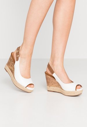 Valkoiset wedge-sandaalit avonaisella varpaalla, korkki- ja punottu juuttidetalji, sekä säädettävä slingback-hihna. Sileä nahkamainen materiaali.
