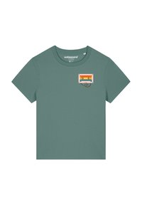 T-shirt vert en tissu doux avec un petit graphisme de cassette audio colorée sur la partie gauche de la poitrine. Manches courtes et col rond.