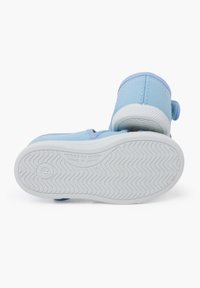 Vaaleansininen kangaskenkä, jossa on teksturoitu päällinen, tarranauha ja valkoinen kumipohja, jossa on sahalaitakuvio.