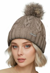 Knitted beige beanie with a ribbed design and a large faux fur pom-pom on top, featuring an embroidered logo on the front.
