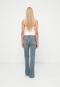 Lyseblå vidbukser laget av denim, med høy midje, fem-lommers design og subtile sømdetaljer. Jevn tekstur med minimal slitasje.