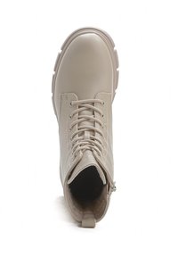 Stivale alla caviglia in pelle beige con punta rotonda, sistema di allacciatura, zip laterale e suola testurizzata. Interno foderato per il comfort. Design con tacco piatto.