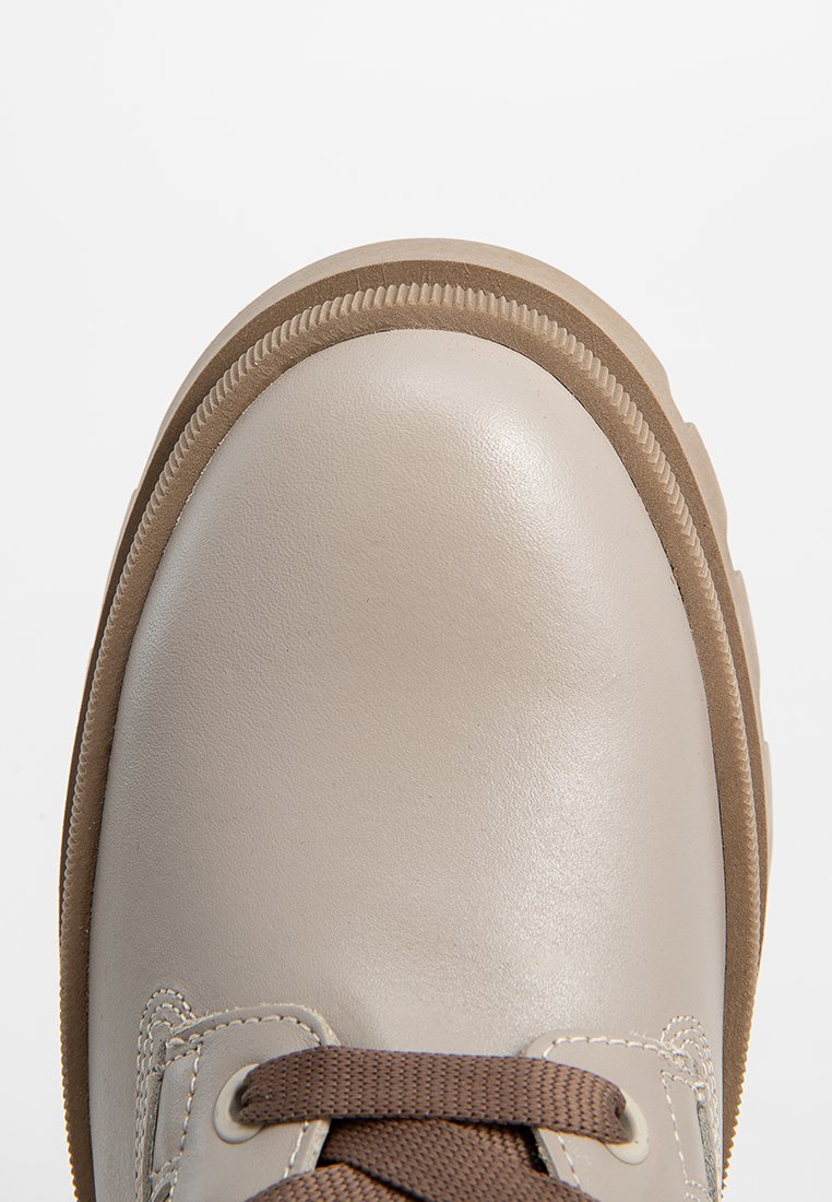Beige Leder Schuh mit runder Zehenpartie. Braune Schnürsenkel und Gummisohle mit strukturierten Rändern. Glatte Oberfläche, minimale Nähdetails.