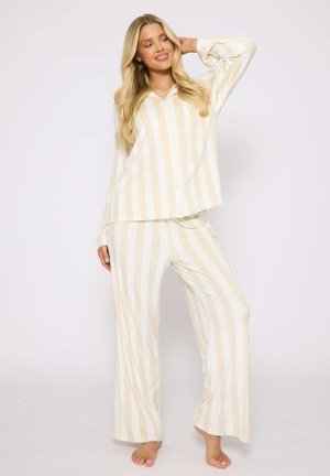 Lightweight, striped pajama set in cream and beige. Long-sleeved shirt with button front and matching loose-fit pants. Soft fabric texture.