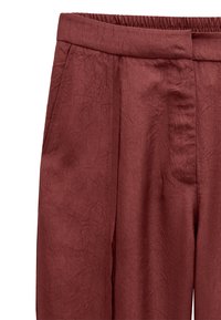 Bordowe spodnie wykonane z fakturowanej tkaniny o pomarszczonym wykończeniu, z płaskim paskiem w talii, bocznymi kieszeniami i plisami z przodu.