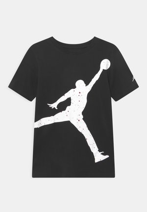Camiseta de algodón negra con una gran silueta blanca de un jugador de baloncesto en movimiento, acentuada con manchas rojas salpicadas.