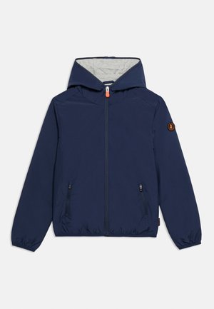 Giacca con cappuccio blu navy con fodera interna grigia, cerniera frontale, due tasche con zip, polsini elastici e patch con logo sulla manica sinistra.