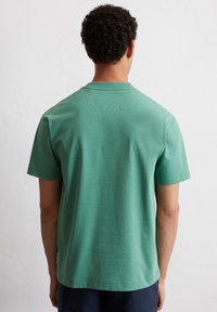 Groen katoen T-shirt met korte mouwen en een ronde hals, met een soepele textuur en minimalistische stikdetails langs de zoom.