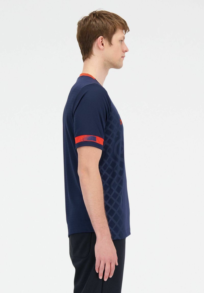 Camiseta deportiva de color navy con cuello redondo, mangas cortas con acentos rojos y un patrón geométrico texturizado en el frente.