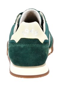 Zelená semišová sportovní bota s krémovými akcenty. Obsahuje polstrovaný límec, texturovanou patu a na zadní straně je embosované "1949". Gumová podešev.