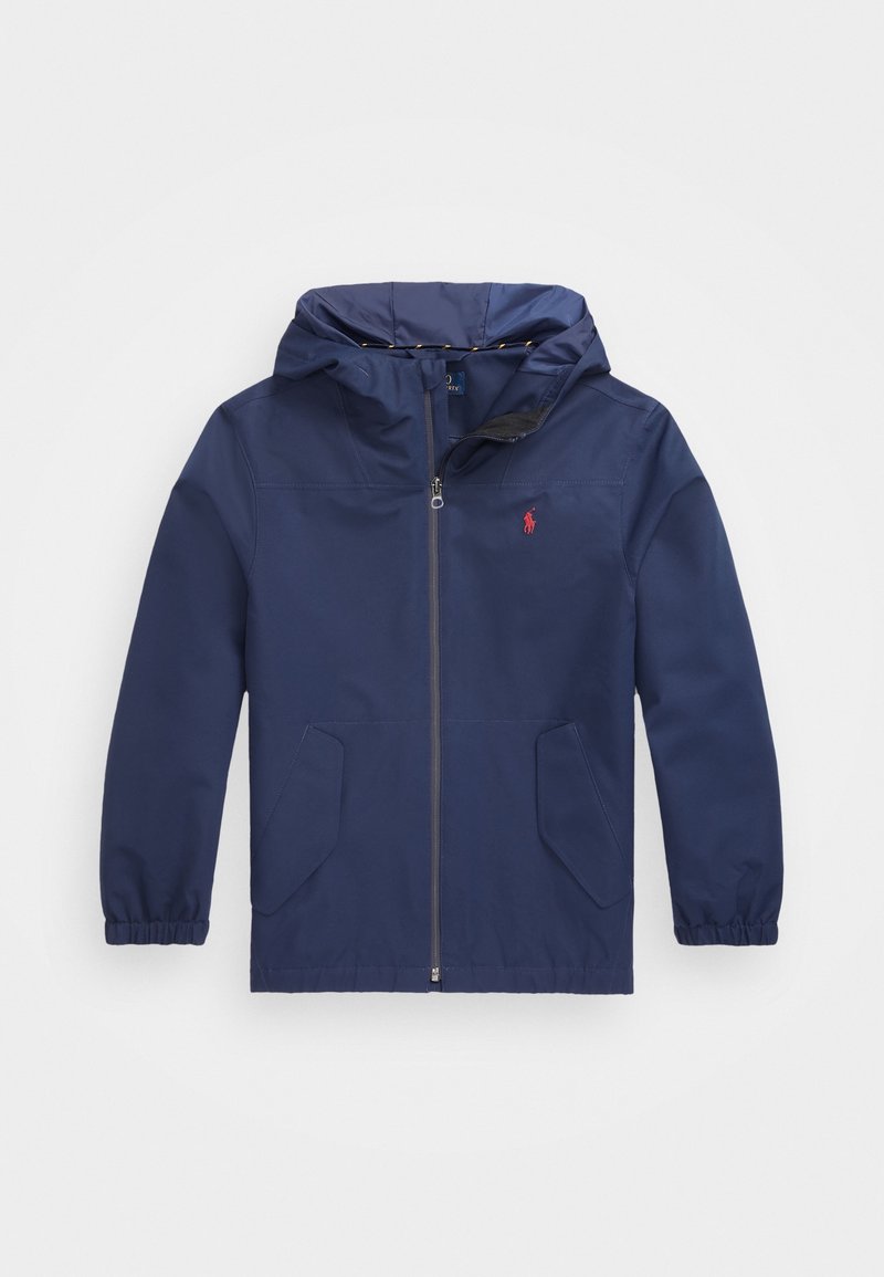 Chaqueta con capucha de color azul marino hecha de material ligero, con cremallera frontal, dos bolsillos laterales y un pequeño logo rojo en el pecho.