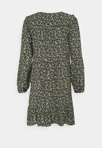 Robe à manches longues, vert foncé à motifs floraux avec petites fleurs blanches et jaunes, taille froncée et ourlet volanté, vue de dos.