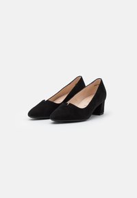 Zapatos de ante negros con un tacón bajo y cuadrado, puntera afilada y un detalle cortado en la parte frontal. Forro interior suave.