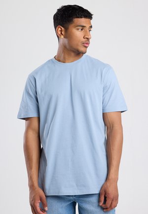 Lichtblauw T-shirt met korte mouwen gemaakt van zachte katoenstof, met een klassieke ronde hals en een relaxed fit. Geen zichtbare patronen of accenten.