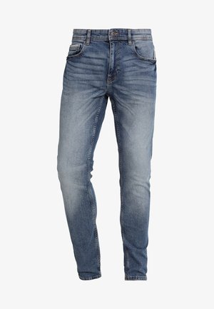 Jean en denim bleu coupe slim avec délavage, fermeture avant par bouton et zip, et design à cinq poches.
