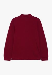 Burgunderfarbens Langarm-Polohemd mit Kragen, gerippten Bündchen und einer weichen Stofftextur. Rücken schlicht ohne sichtbare Logos oder Muster.