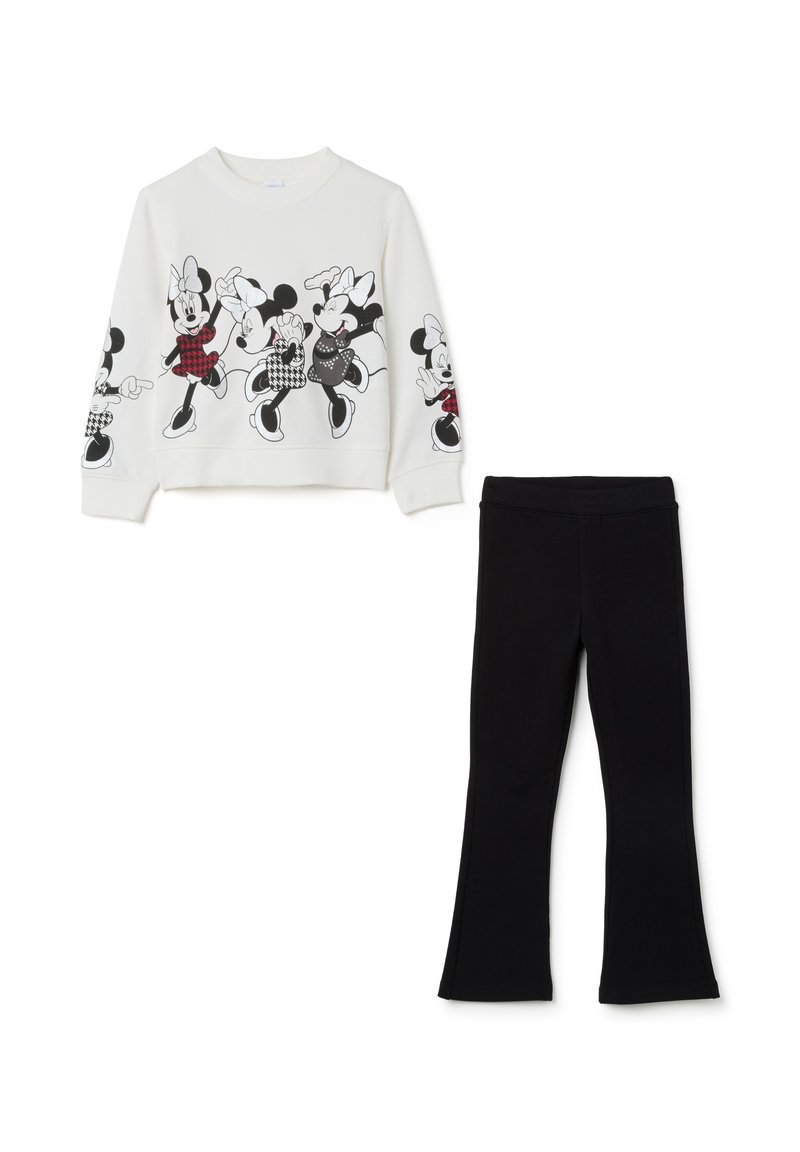 Sweatshirt blanc avec des imprimés graphiques noirs de personnages de dessin animé, associé à des leggings évasés noirs. Texture de tissu lisse sur l'ensemble.
