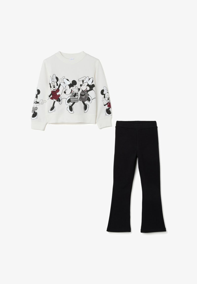 Witte sweatshirt met zwarte grafische prints van cartoonfiguren, gecombineerd met zwarte flare leggings. Gladde stoftextuur in het geheel.