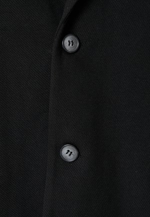 Czarna tkanina odzieżowa o gładkiej fakturze, z dwoma czarnymi guzikami i subtelnym wzorem tkanym. Zaprojektowana w klasycznym, dopasowanym kroju.