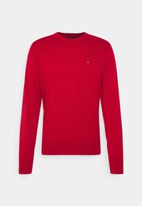 Roter Baumwollpullover mit langen Ärmeln und Rundhalsausschnitt. Kleines Logo-Detail auf der Brust. Glatte Textur und taillierte Passform.