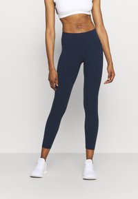 Marineblaue Sportleggings aus dehnbarem Stoff mit hohem Bund, ausgestattet mit einer glatten Textur und subtilen Nahtdetails.