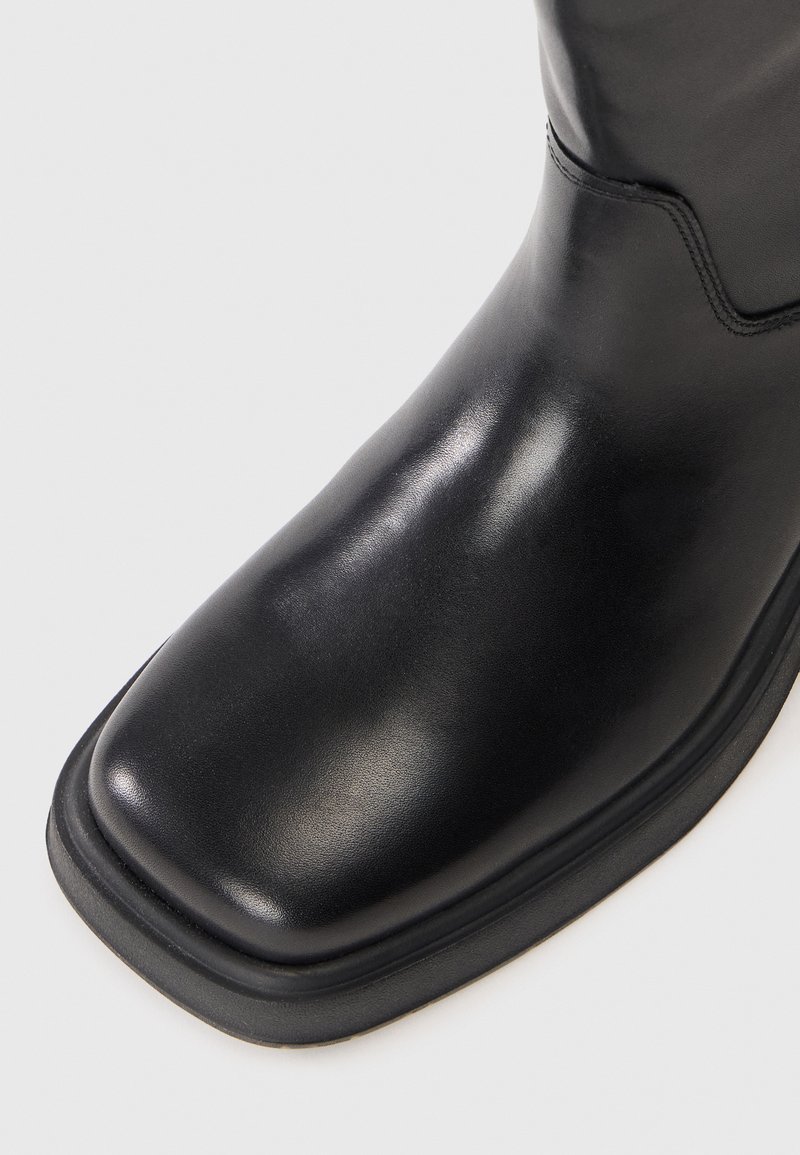 Schwarze Leder-Ankle-Boots mit quadratischer Zehenform, glatter Oberfläche, minimaler Naht und Gummisohle.