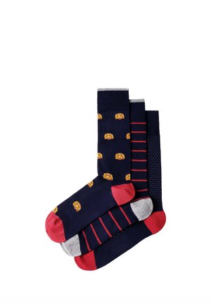 Three pairs of navy socks with red toes; one has yellow dog faces, one red stripes, and one small white dots pattern.