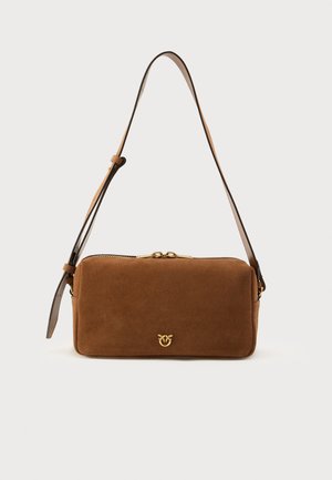 Bolso bandolera de ante marrón con cierre de cremallera, que presenta un detalle de logo dorado. Correa ajustable de cuero con una textura suave.