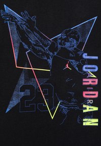 Camiseta negra con un gráfico multicolor de un jugador de baloncesto en movimiento, con formas geométricas angulares y el número "23".