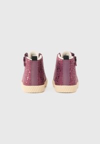 Lila Knöchelstiefel mit strukturiertem Finish, ausgestattet mit einer beigen Gummisohle und einem kontrastierenden Rückenteil. Enthält eine Zuglasche für einfaches Anziehen.