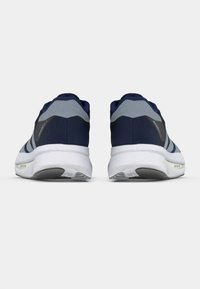 Ζευγάρι αθλητικά παπούτσια σε σκούρο μπλε και γκρι χρώμα, από πίσω, σε απλό λευκό φόντο, με λευκές σόλες και γκρι λεπτομέρειες στη φτέρνα.