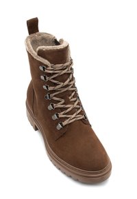 Brązowe zamszowe botki za kostkę z sztucznym futrem w środku, płaską gumową podeszwą, metalowymi oczkami i kontrastującymi ozdobami sznurowania.