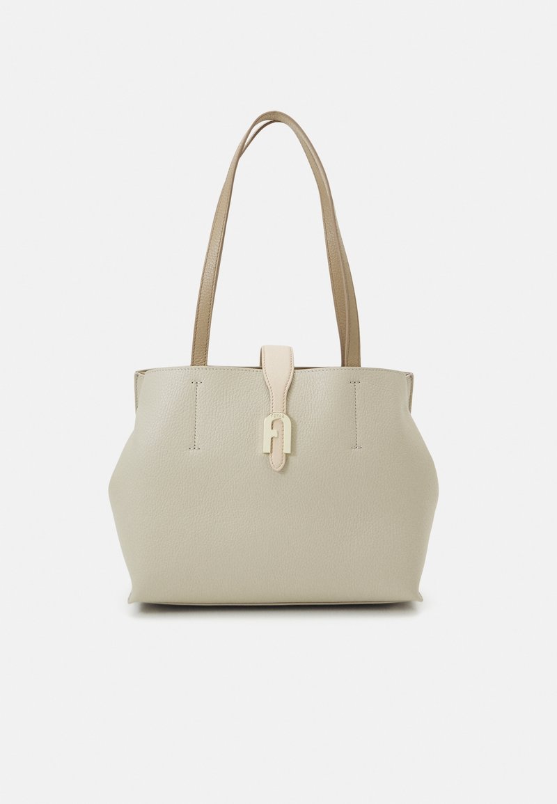 Beige leather tote bag with two sturdy handles, front closure tab, textured surface, and minimalistic design.
